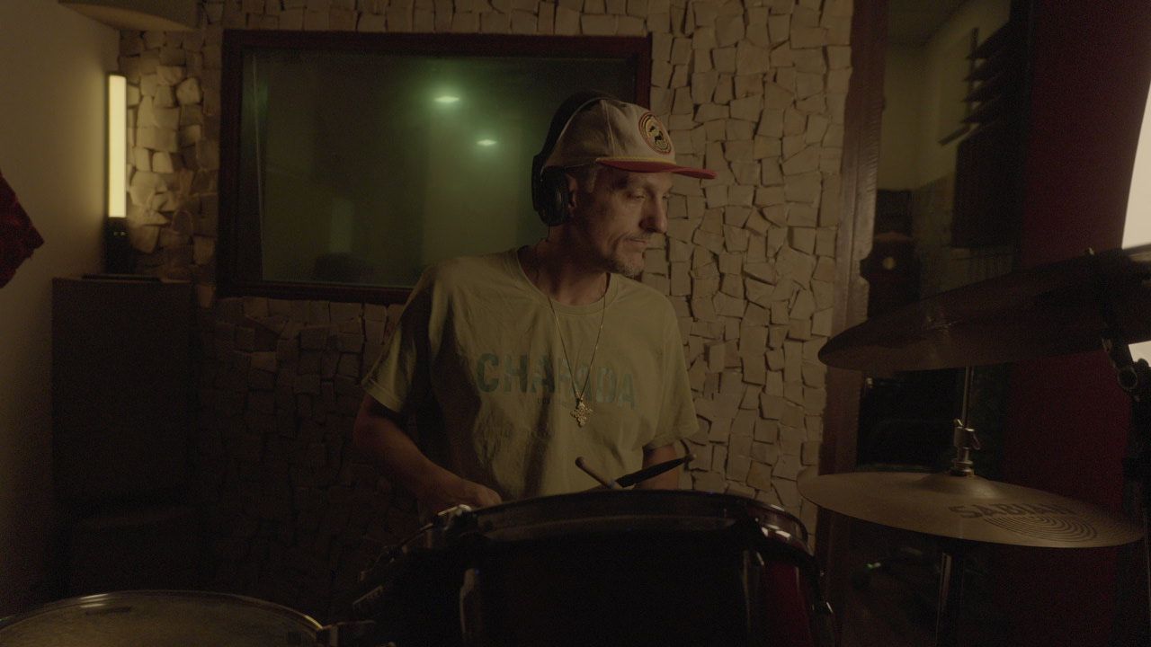 Baterista em estúdio durante captação de bateria com fones de isolamento